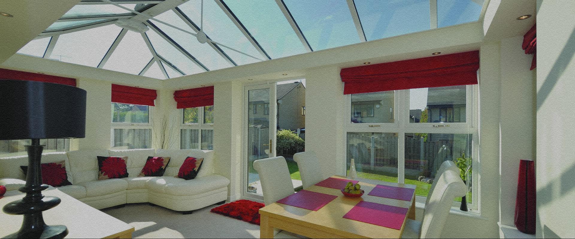Glazed conservatory with an aluminium roof attached to a brick house
