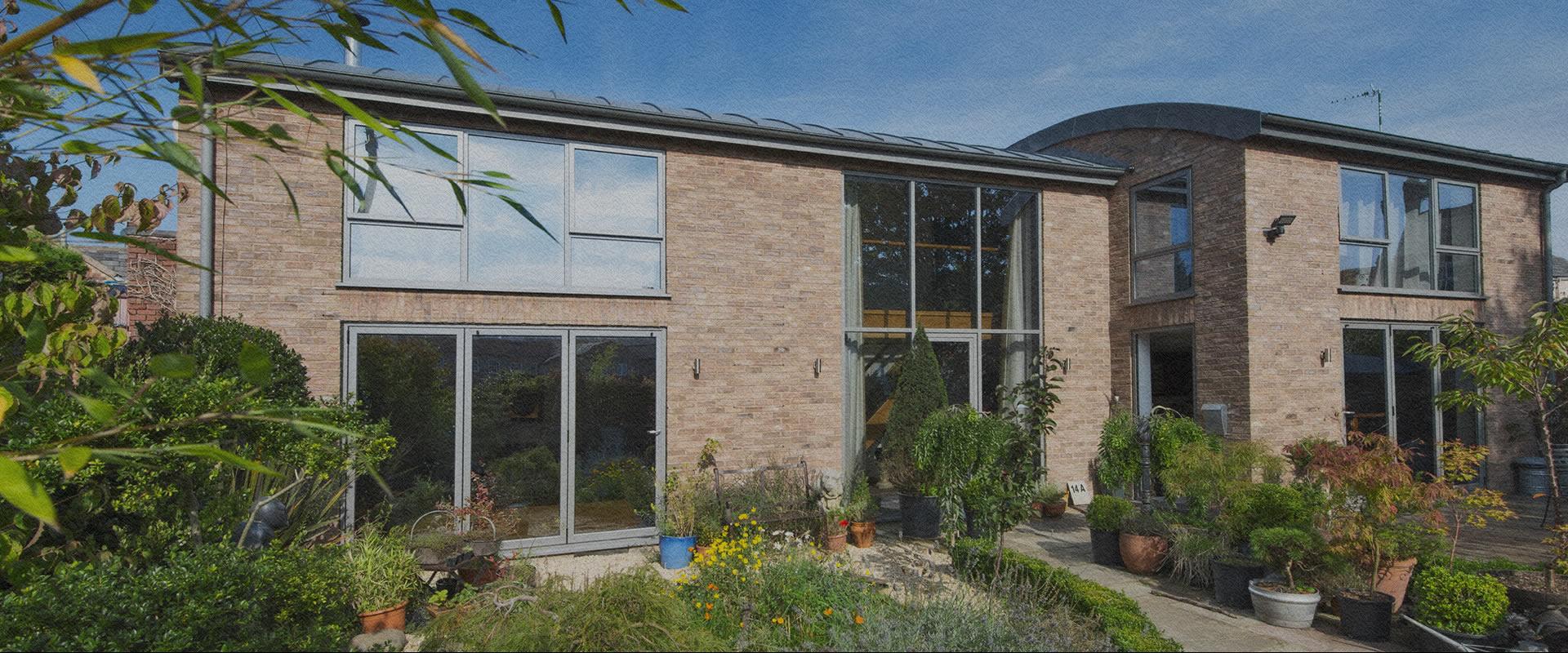 Modern house with large grey aluminium windows overlooking a garden