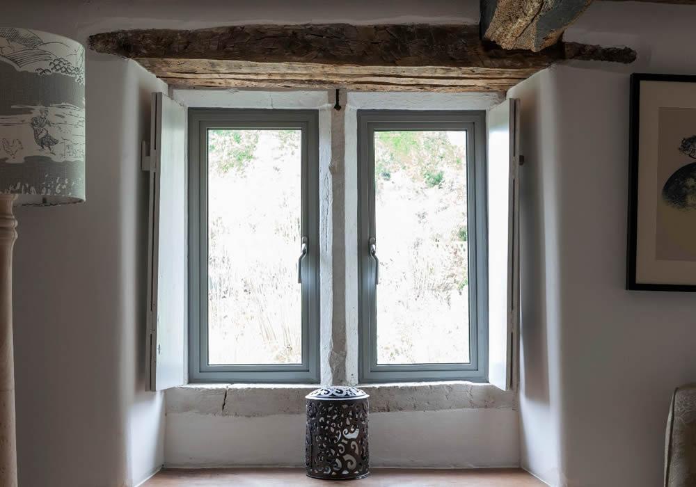 Aluminium window in a room with exposed brick