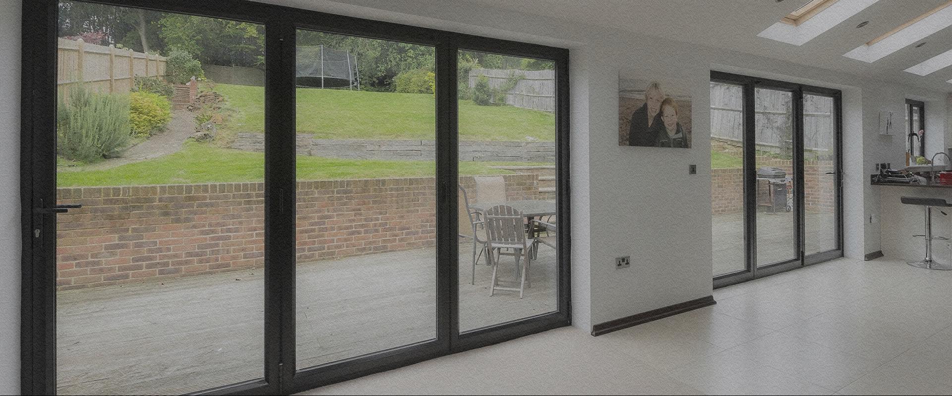 Anthracite aluminium bifolding doors opened onto a garden terrace