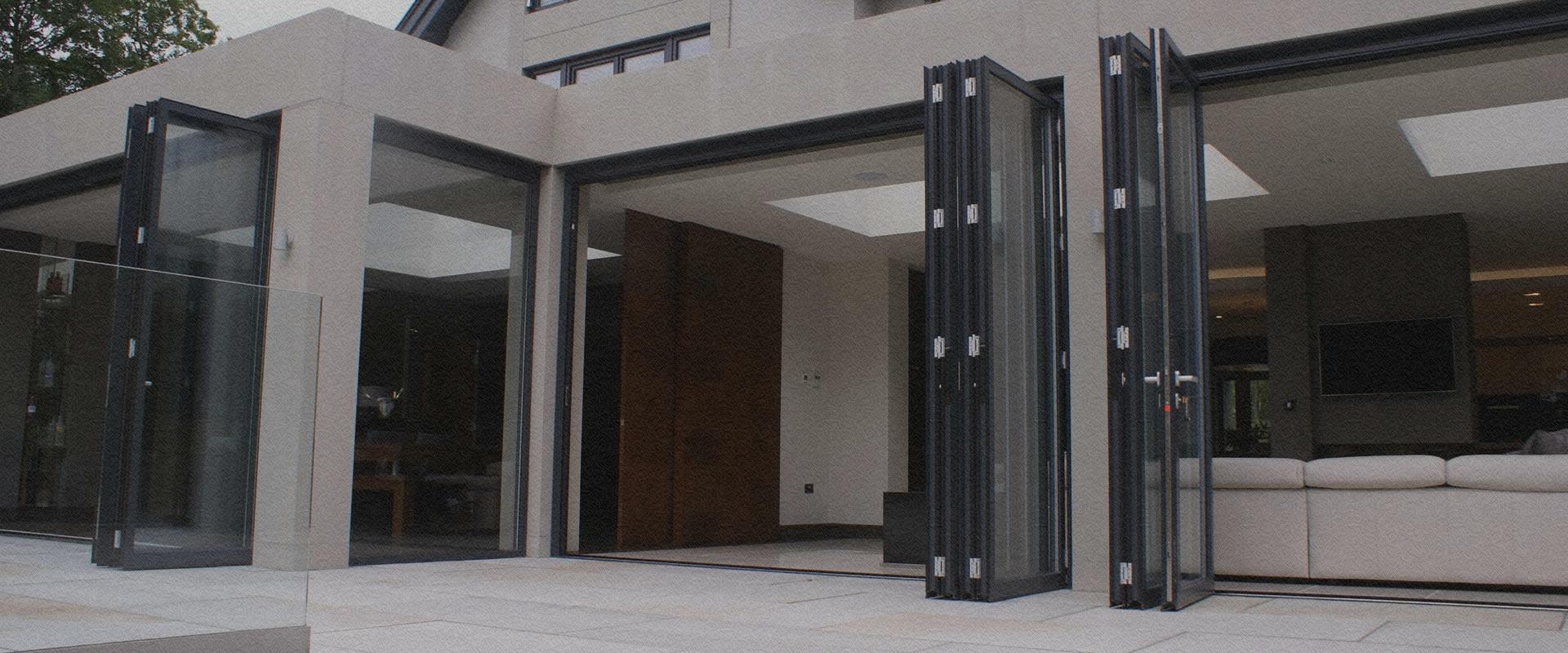 Smart aluminium bifolding doors folded back onto a garden terrace