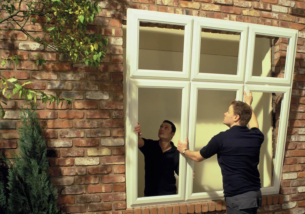 Fitter installing a replacement window in a home