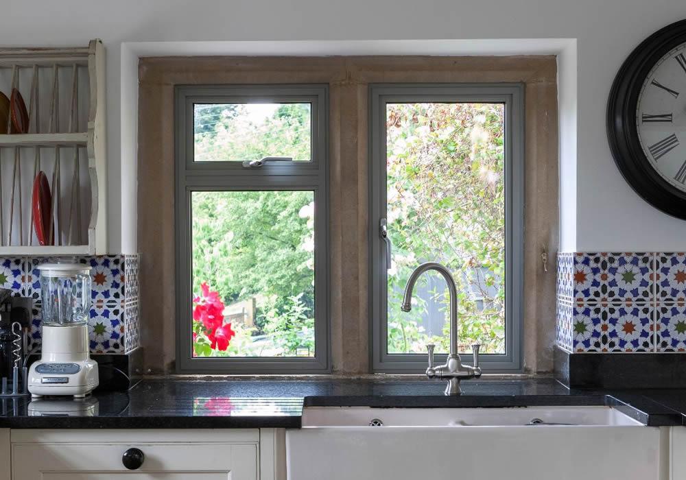 Aluminium kitchen window above a tiled splashback