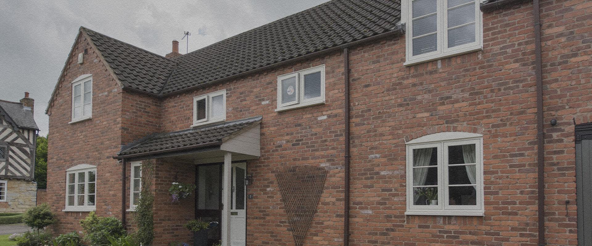 White flush sash windows on a traditional brick cottage